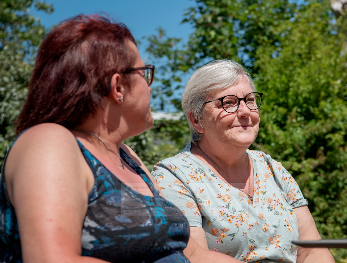 twee dames die genieten van de zon op een terrasje