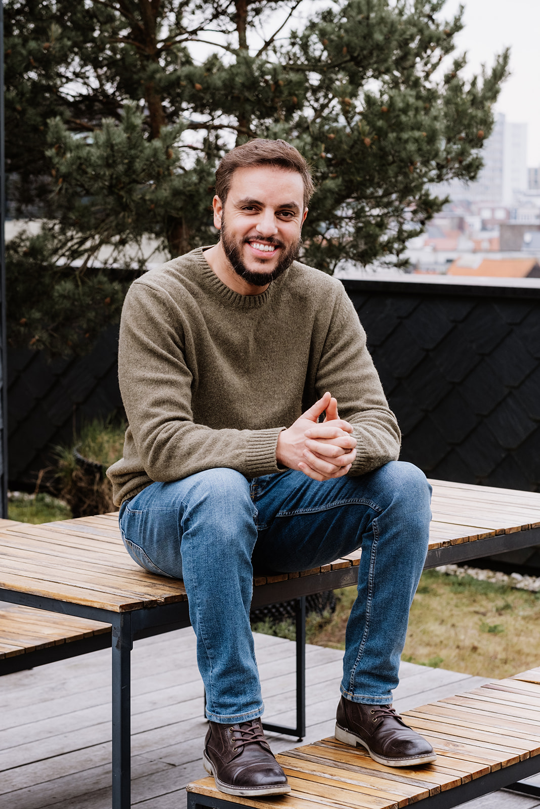 man met bruine haar, ringbaard, kaki t-shirt en jeansbroek