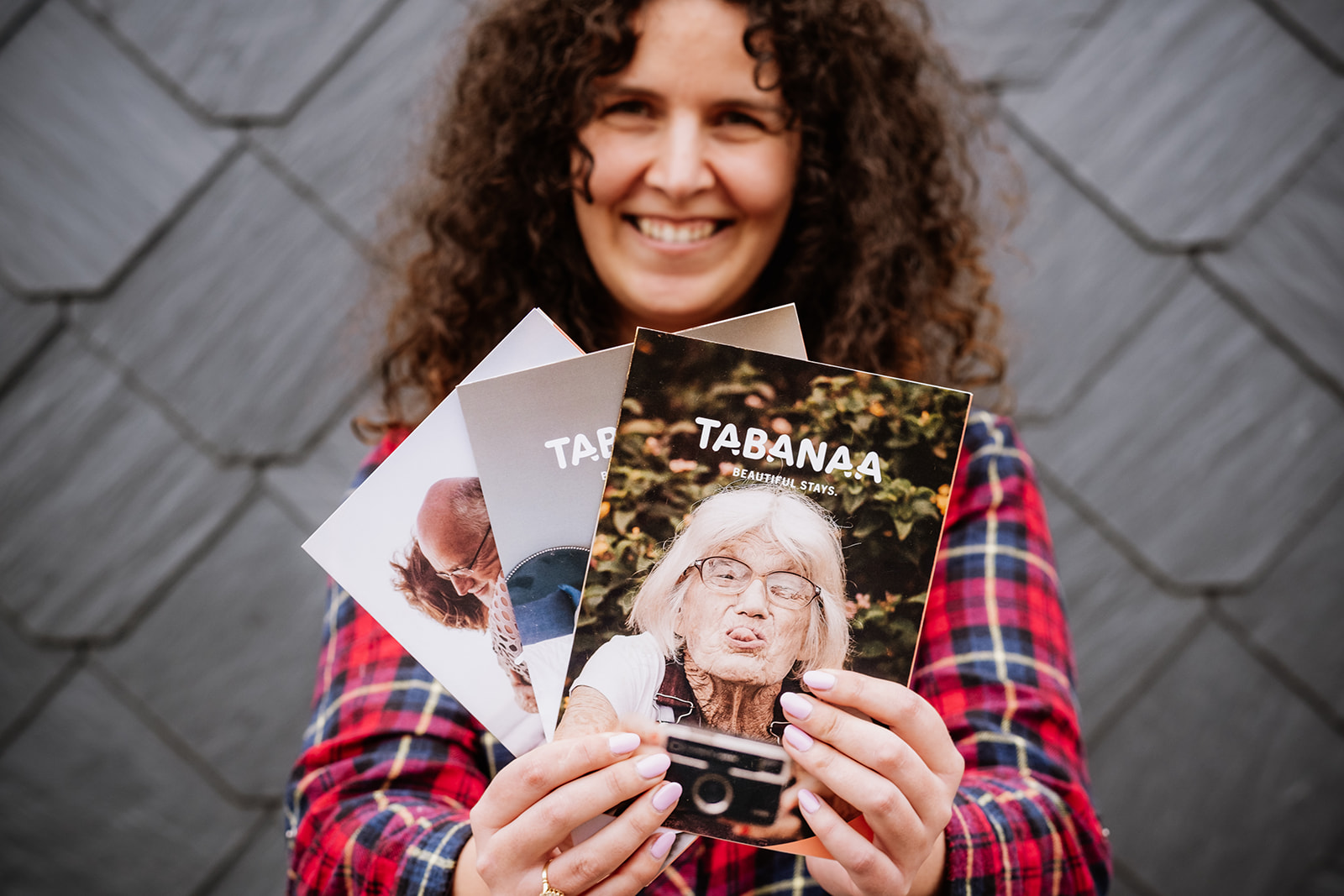 foto van vrouw met donker krullend haar die folders van Tabanaa voor zich gespreid houdt